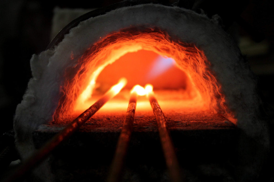 a blacksmith heating metal in a forge