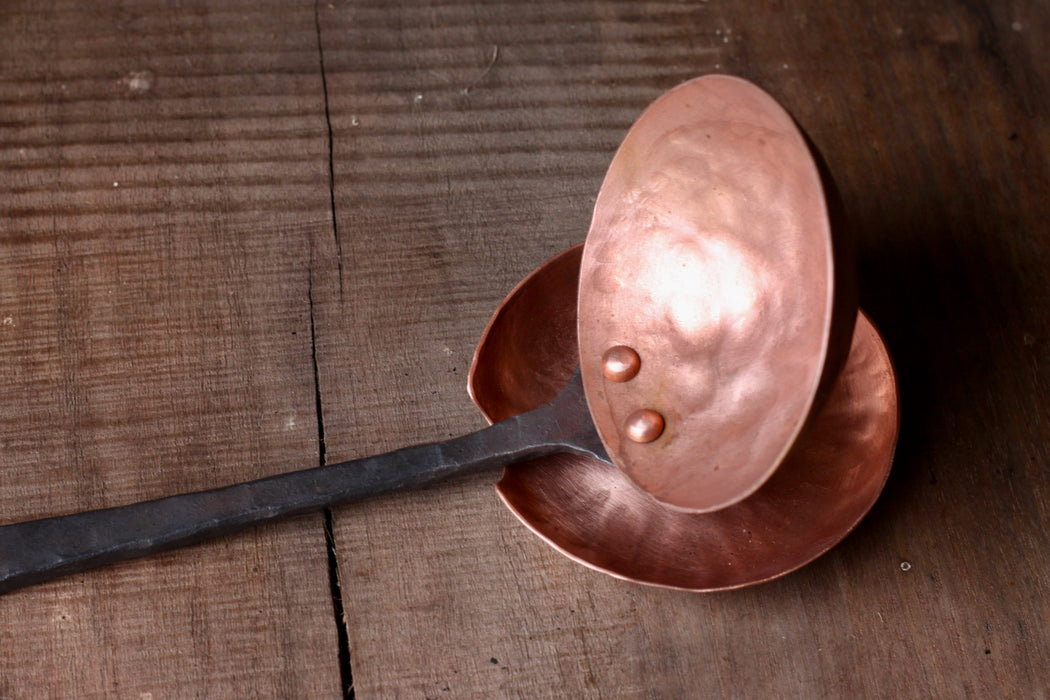 a blacksmith hand forged copper spoon rest under a ladle by Wicks Forge