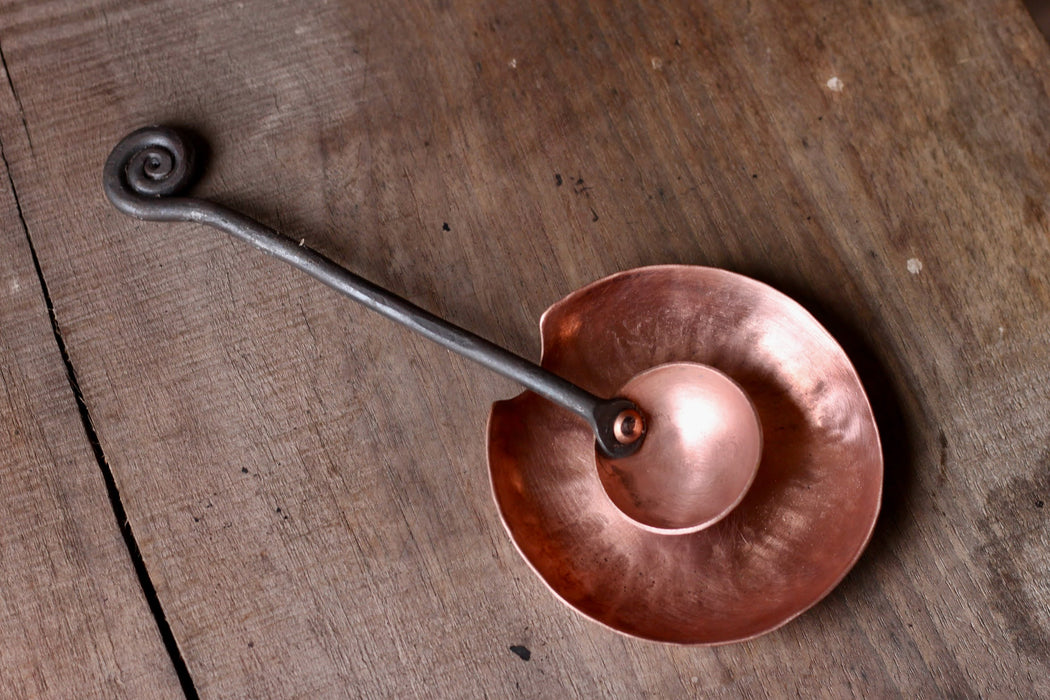 a blacksmith hand forged copper spoon rest under a coffee scoop by Wicks Forge