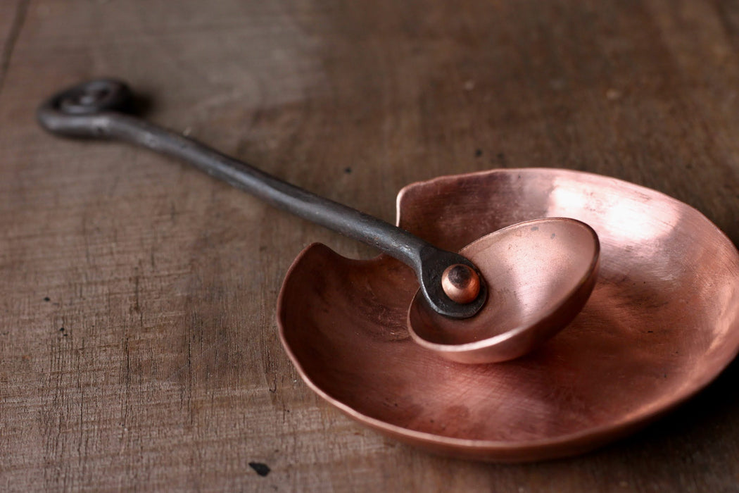 a blacksmith hand forged copper spoon rest under a coffee scoop by Wicks Forge