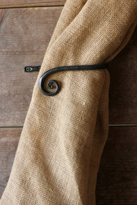 a blacksmith hand forged curtain holdback with a curl design by Wicks Forge