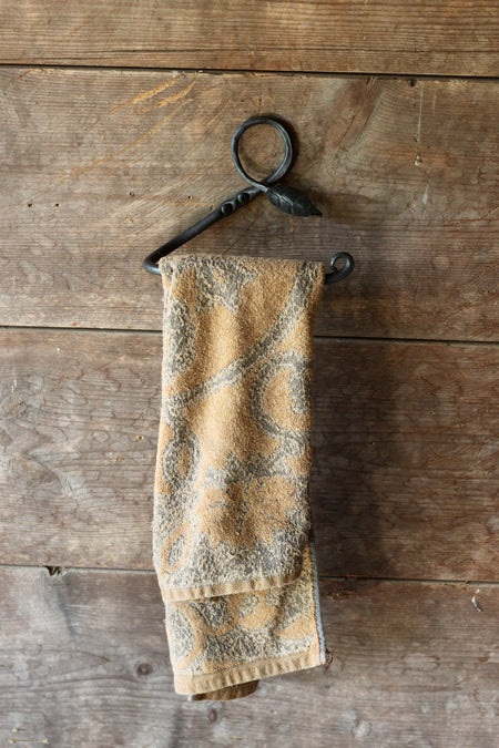 a blacksmith hand forged towel rack with a leaf design by Wicks Forge