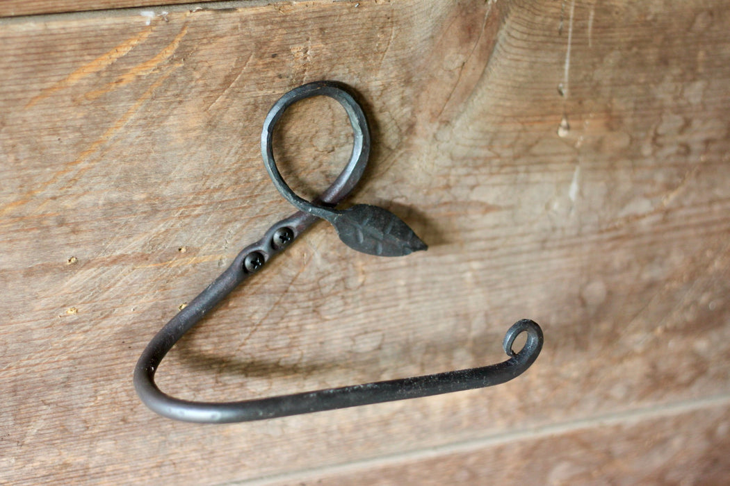 a blacksmith hand forged toilet paper holder with a leaf detail by Wicks Forge