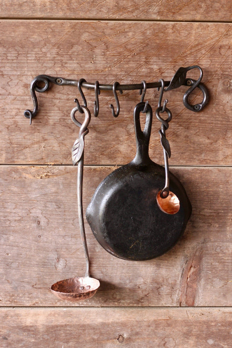 a blacksmith hand forged pot and pan rack with a leaf design by Wicks Forge