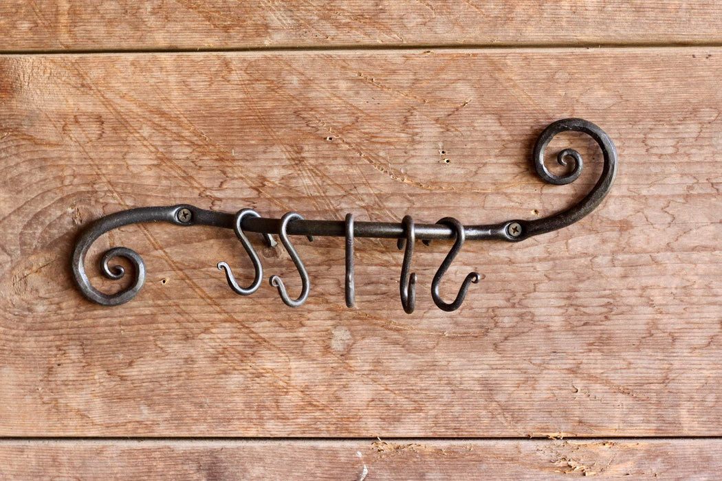 a blacksmith hand forged pot and pan holder with a scrolled design by Wicks Forge