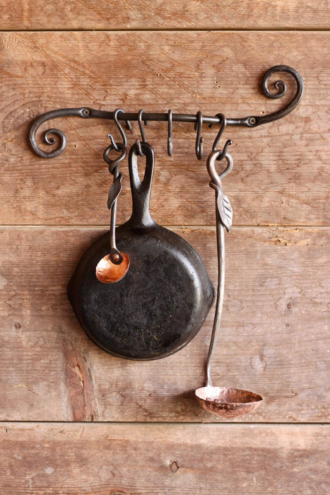 a blacksmith hand forged pot and pan holder with a scrolled design by Wicks Forge