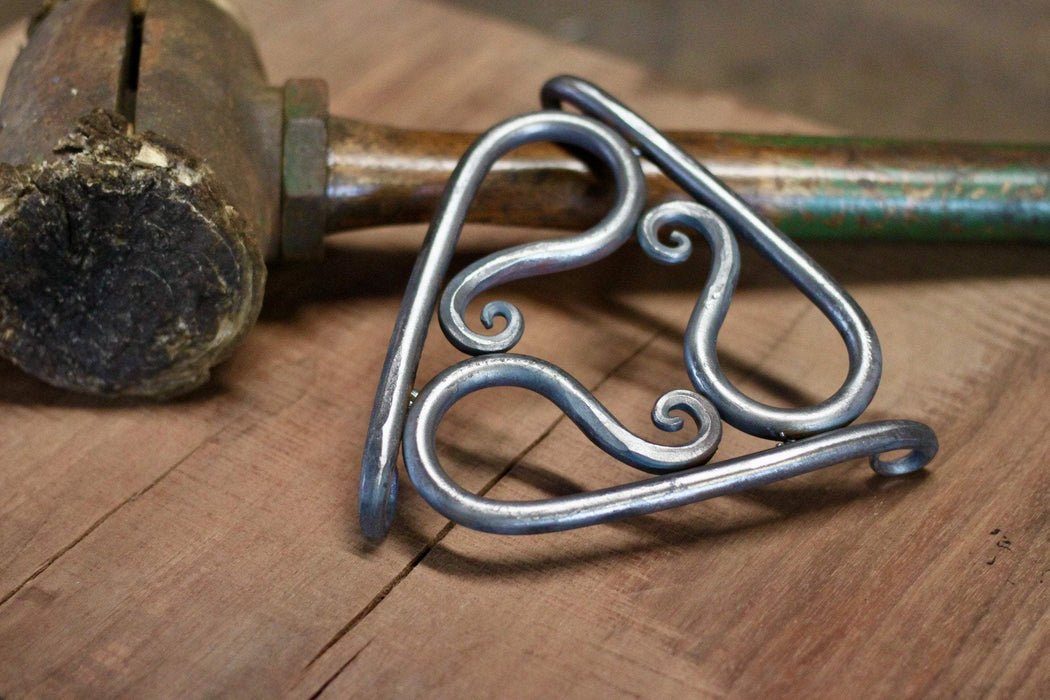 a blacksmith hand forged trivet pot holder by Wicks Forge
