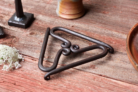trivet on a wood surface with accessories around 