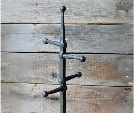 fire tools stand prongs showing against a wooden wall 