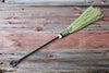 fireplace bristle broom with hand forged iron handle on a wooden surface by wicks forge 