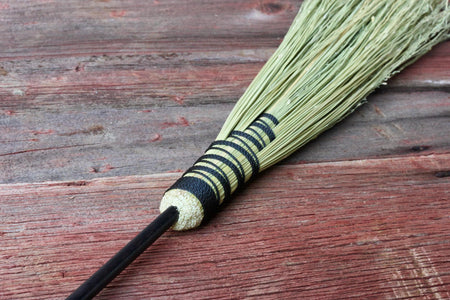 fireplace broom against a wood background 