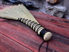 a broom on a wooden table and rustic stone wall in the background 