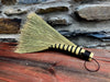 Broom with black and yellow handle on a wooden surface and stone wall background