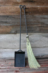 a broom and shovel against a wooden wall 