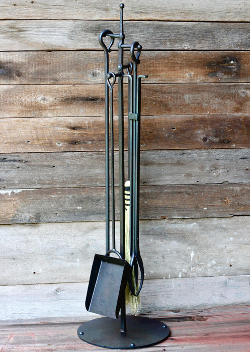 fireplace tools on a stand against a wooden background by wicks forge 