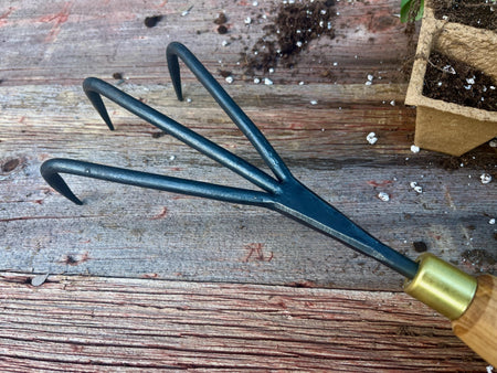 Garden fork with wooden handle on a wooden surface