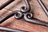 close up of scrolls of trivet on a wood surface 
