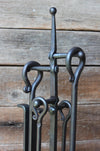 fire tool stand handles against a wood wall 