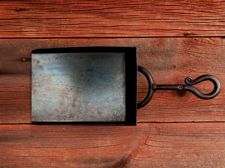 a black shovel on a wooden table 