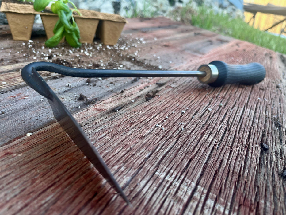 balc garden weeder on a wooden surface with a plant by wicks forge 