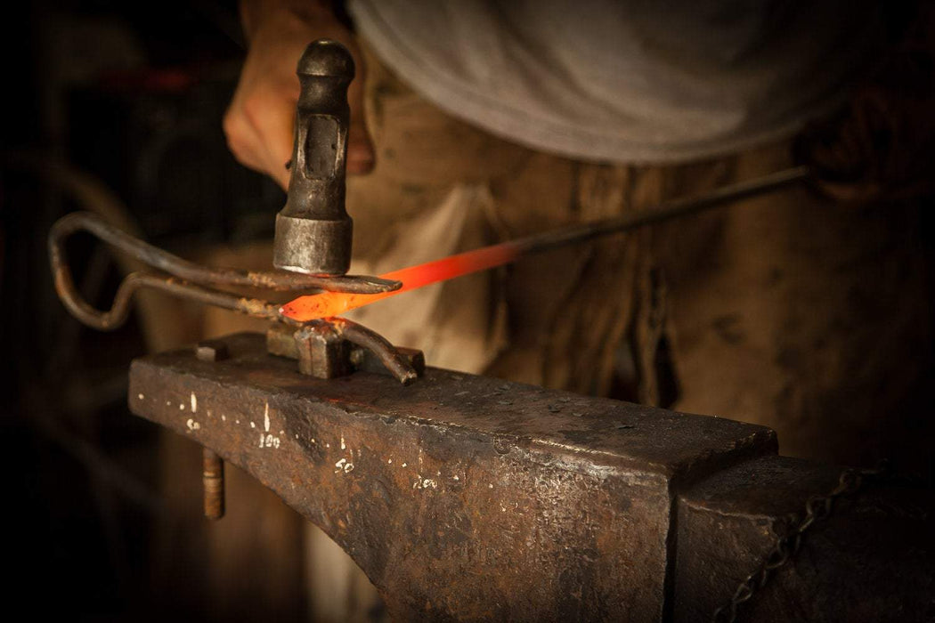 a blacksmith forging metal on an anvil