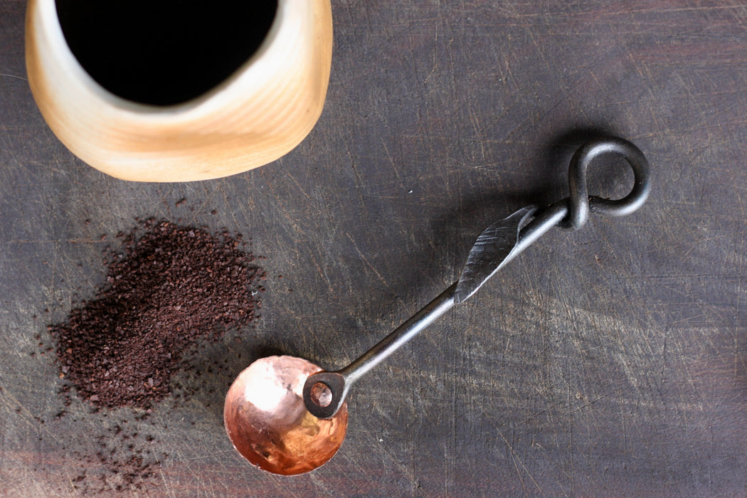 a blacksmith hand forged copper and steel coffee scoop with a leaf handle by Wicks Forge