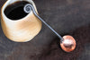 a blacksmith hand forged copper and steel coffee scoop with a fiddlehead handle by Wicks Forge