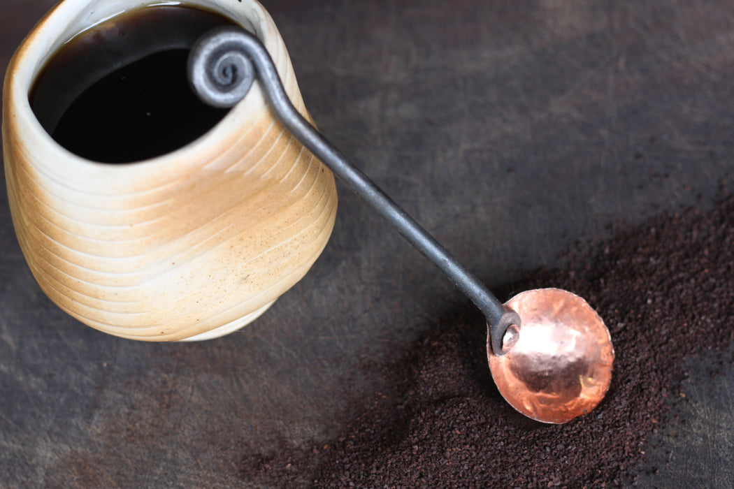 a blacksmith hand forged copper and steel coffee scoop with a fiddlehead handle by Wicks Forge