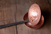 a blacksmith hand forged copper spoon rest under a ladle by Wicks Forge