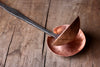 a blacksmith hand forged copper spoon rest under a ladle by Wicks Forge