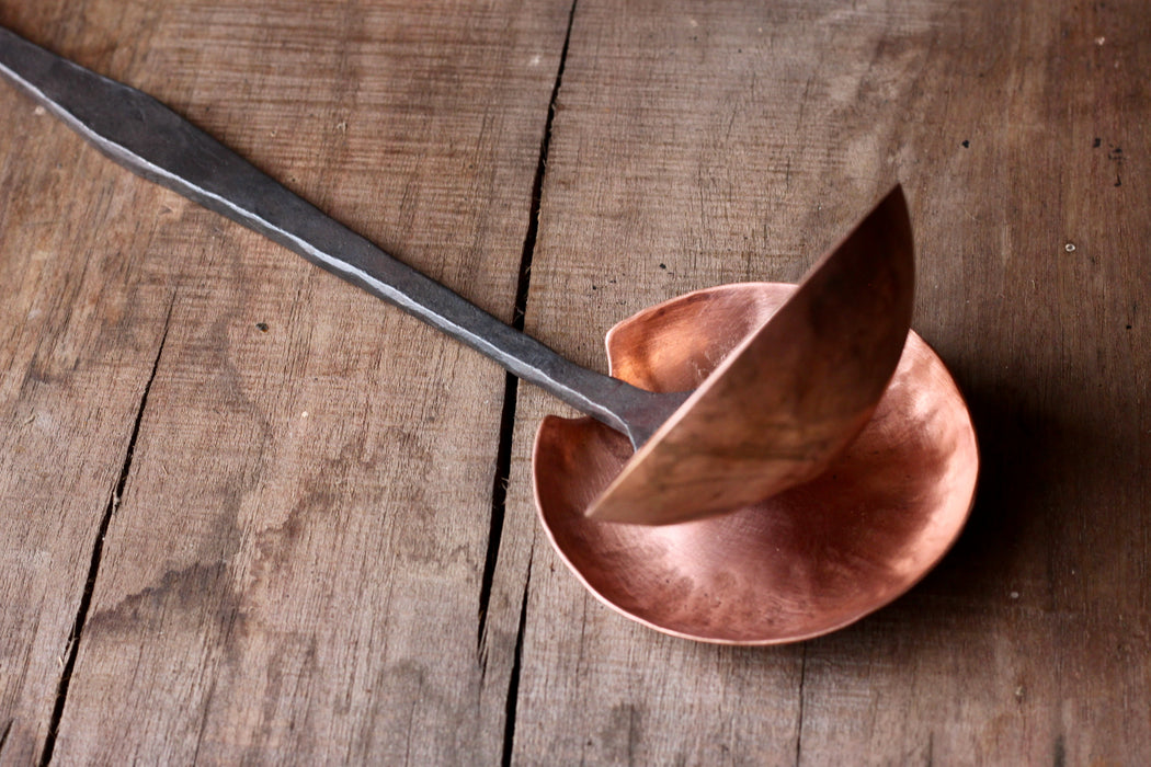a blacksmith hand forged copper spoon rest under a ladle by Wicks Forge