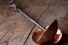 a blacksmith hand forged copper spoon rest under a ladle by Wicks Forge