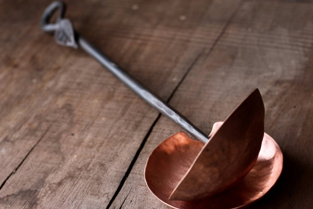 a blacksmith hand forged copper spoon rest under a ladle by Wicks Forge