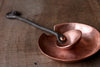 a blacksmith hand forged copper spoon rest under a coffee scoop by Wicks Forge