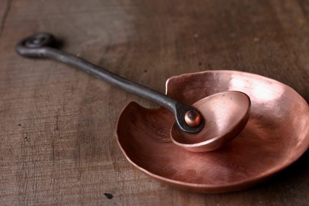 a blacksmith hand forged copper spoon rest under a coffee scoop by Wicks Forge