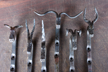 a collection of animal head hooks by Wicks Forge, including a Bull, Gazelle, Unicorn, Longhorn, Ram, and Antelope