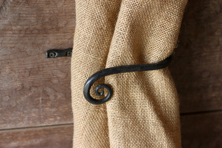 a blacksmith hand forged curtain holdback with a curl design by Wicks Forge