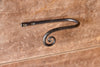 a blacksmith hand forged curtain holdback with a curl design by Wicks Forge