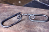 a set of blacksmith hand forged curtain holdback with a curl design by Wicks Forge