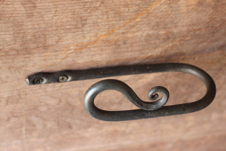 a blacksmith hand forged curtain holdback with a reverse curl design by Wicks Forge