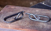 a set of blacksmith hand forged curtain holdback with a reverse curl design by Wicks Forge