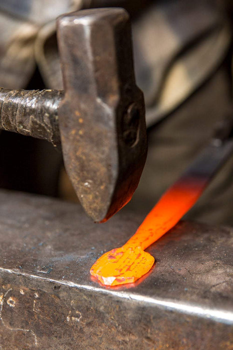 a blacksmith forging an egg spoon handle out of heated steel by Wicks Forge