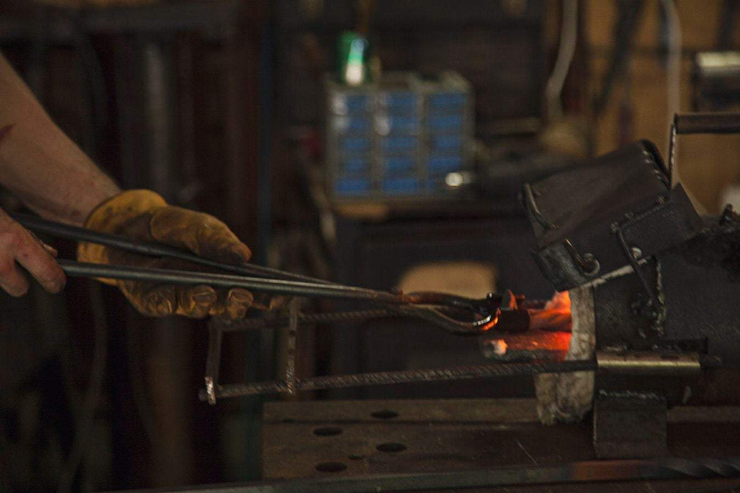 a blacksmith heating metal in a forge