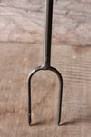 prong of a campfire roaster on a wooden surface 