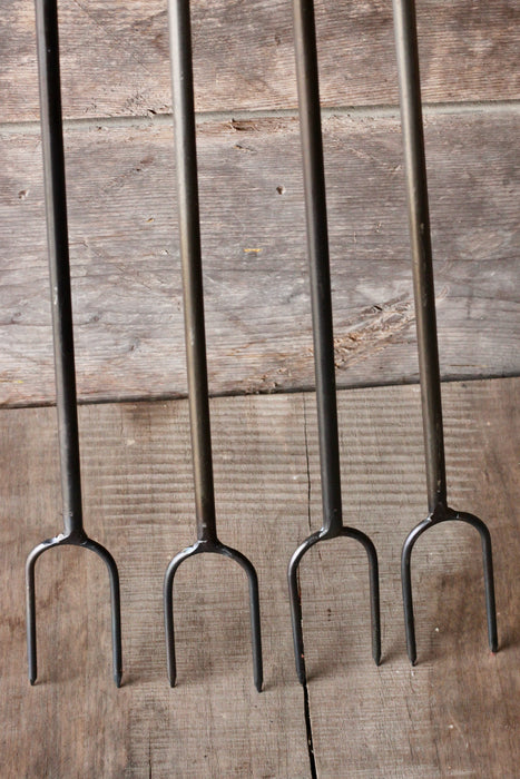 4 campfire roasters by wicks forge against a wooden wall 