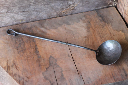 a blacksmith hand forged egg spoon with a curled handle by Wicks Forge
