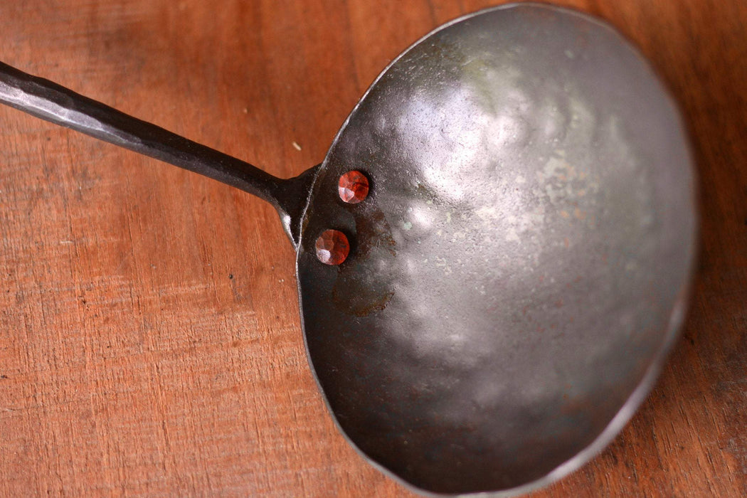 a blacksmith hand forged egg spoon with a curled handle by Wicks Forge