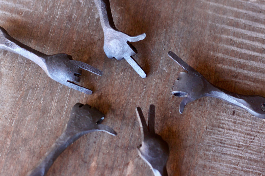 hand keychains by wicks forge on a wooden surface 