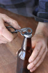 a blacksmith hand forged bottle opener with a leaf design by Wicks Forge