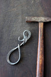 a blacksmith hand forged bottle opener with a leaf design by Wicks Forge